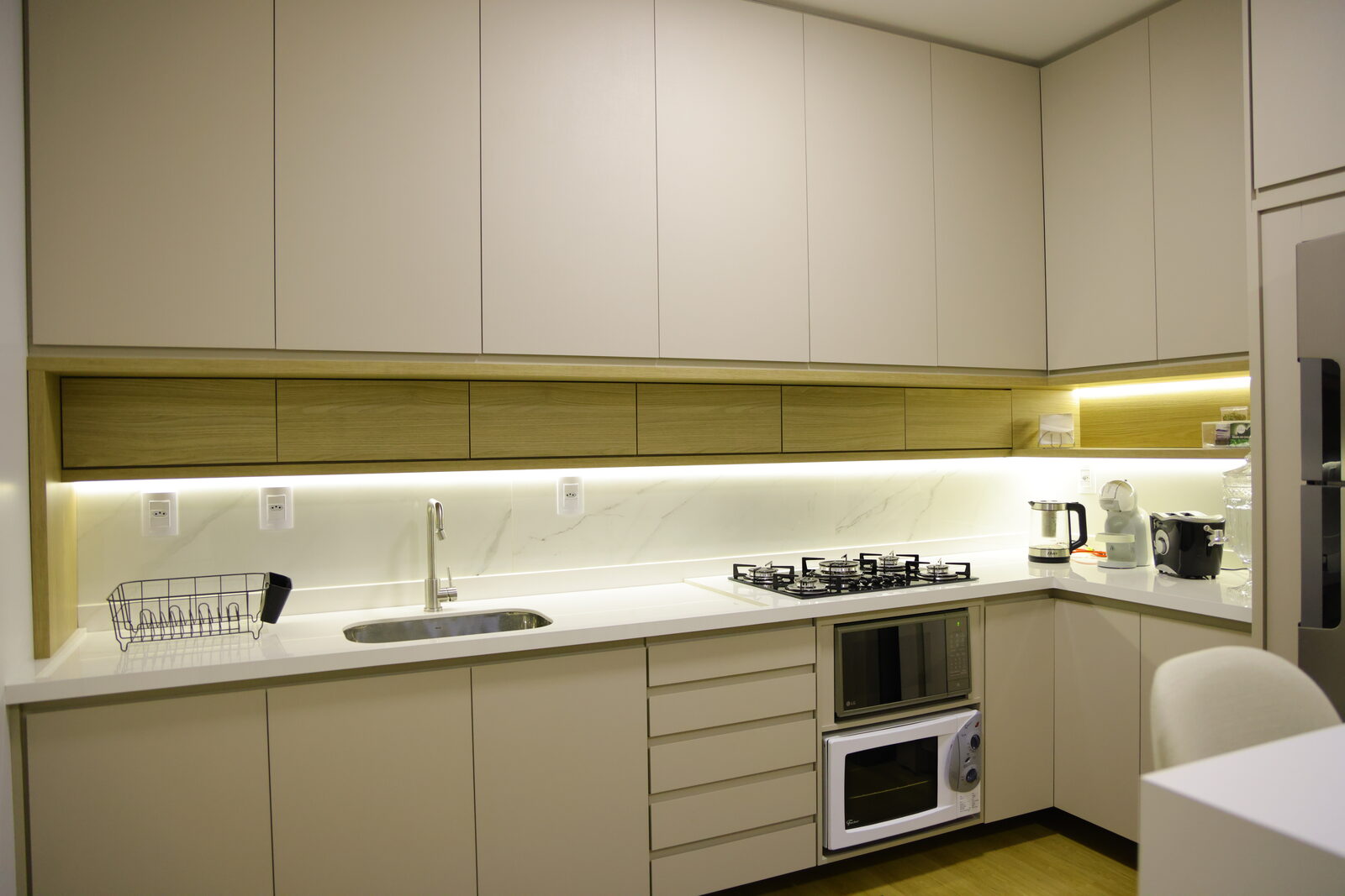 Bancada de cozinha em pedra clara com veios e torneira embutida