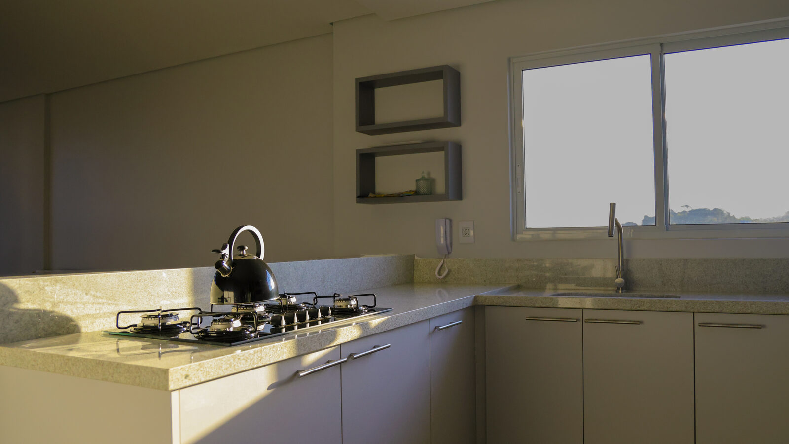 Ilha de cozinha em superfície clara com cooktop e lateral em 45 graus