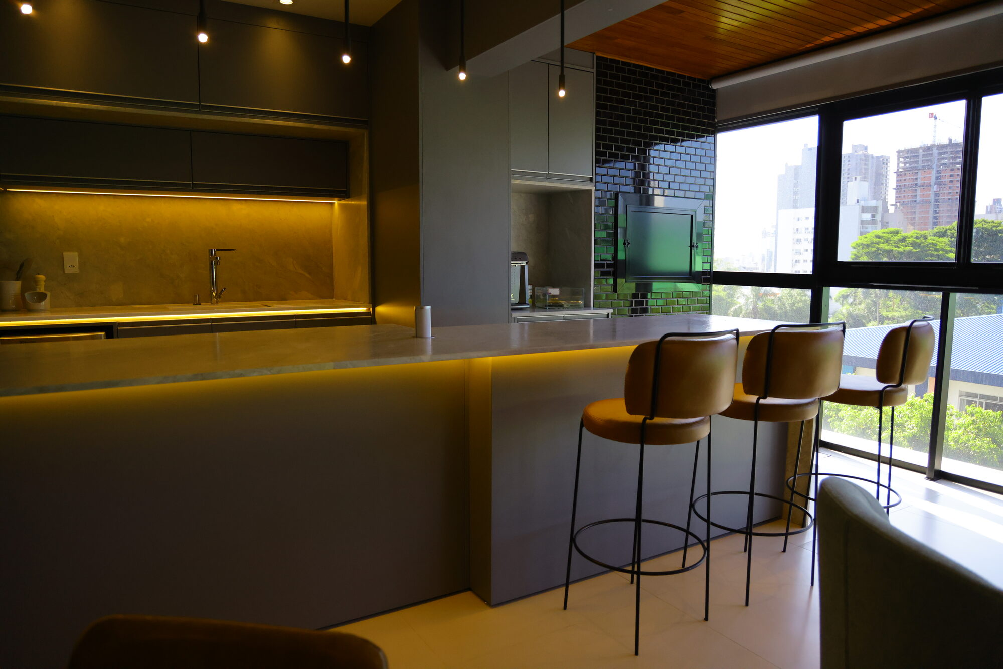 Bancada e painel em pedra natural em cozinha integrada executada pela Casa Stone